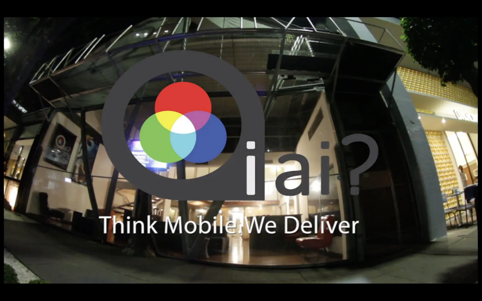 Espaço físico iAi? à noite — foto fisheye com marca Think Mobile We Deliver
